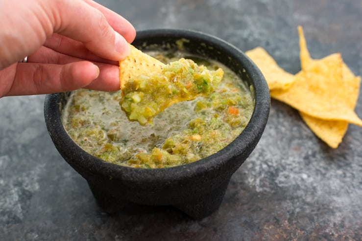 Texas Green Salsa being scooped with a chip