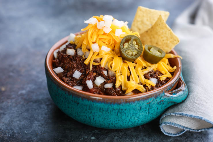 A big bowl of bison chili with a napkin