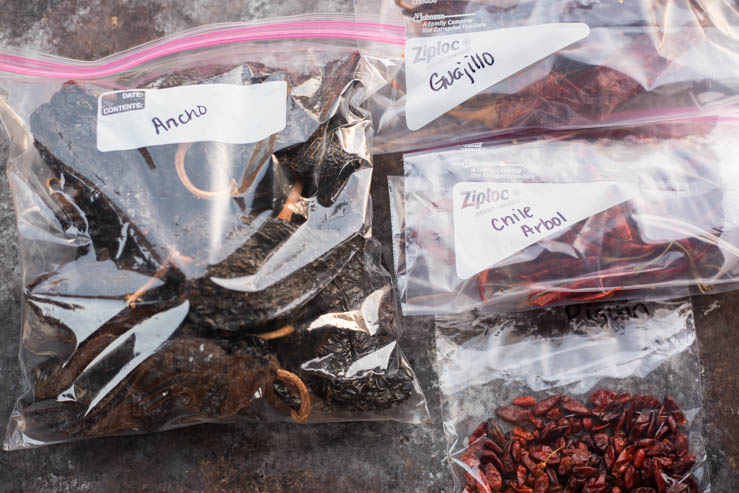 A variety of dried chile peppers kept in baggies.