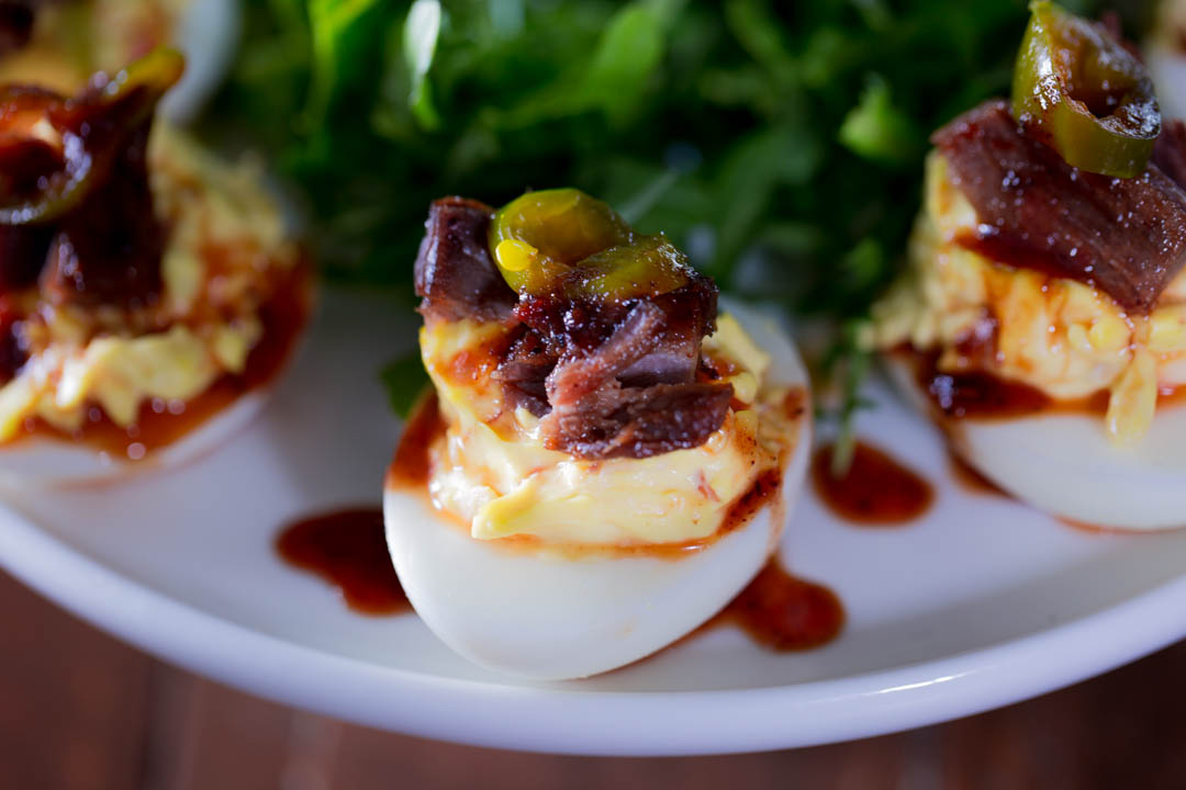 A close up of a brisket deviled egg with candied jalapeno 