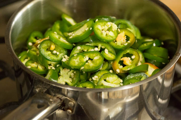 Preparing to make the cowboy candy, jalapenos are added to a saucepot. 