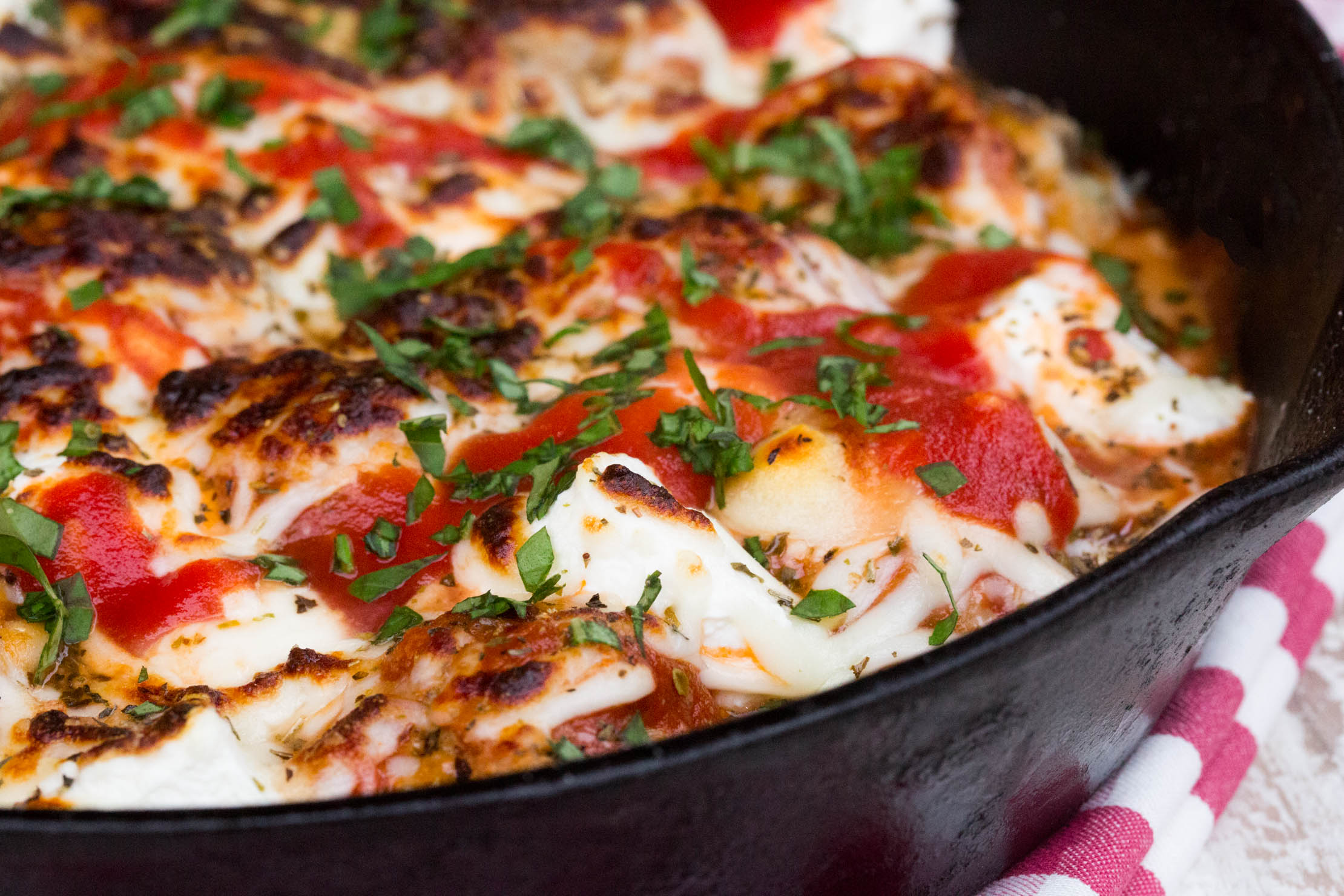 Easy Meatballs recipe displayed in a cast iron skillet, topped with cheese.