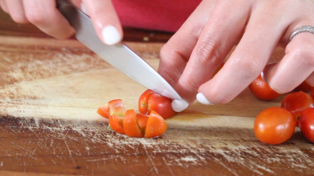 Chopping cherry tomatoes for the top of the brisket queso