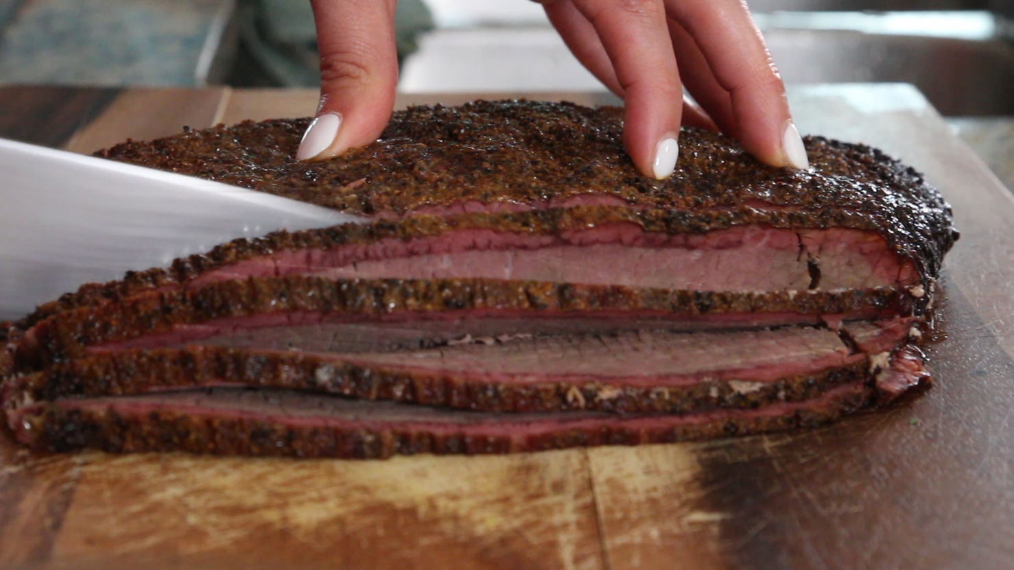 A photo of brisket being sliced for the brisket queso 