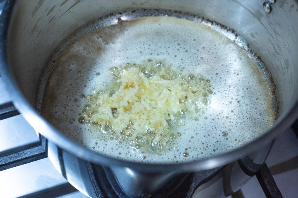 Knoblauch in geschmolzener Butter für das Rezept für weiße Sauce 