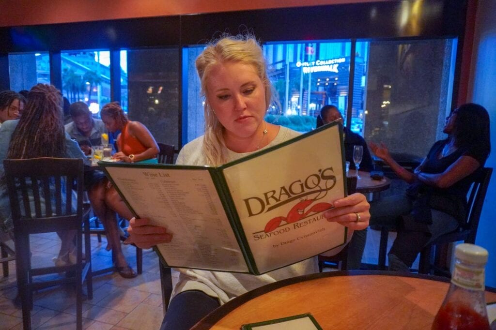 Sarah reading the menu at Drago's Seafood Restaurant 