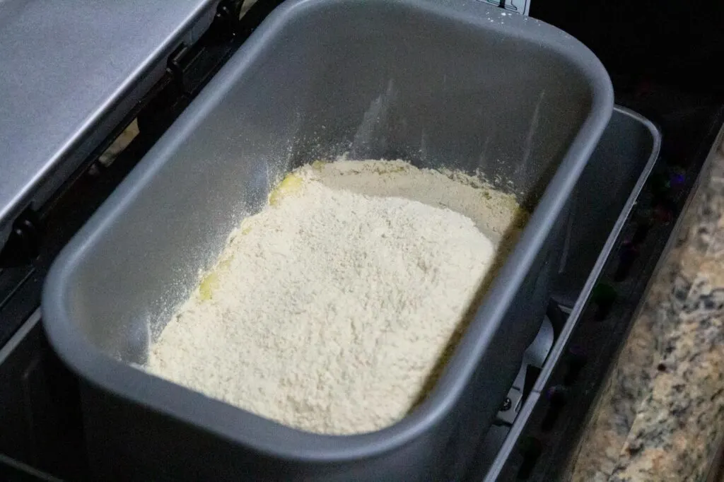 The bowl of the bread machine with all ingredients added
