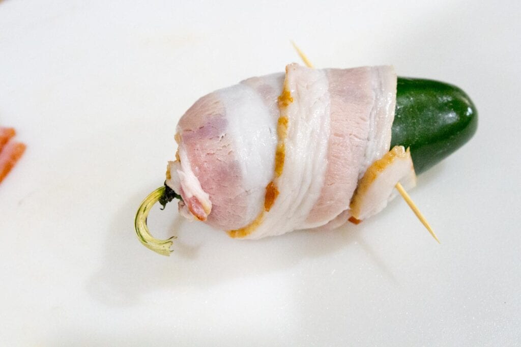 Securing stuffed jalapeno peppers with a toothpick