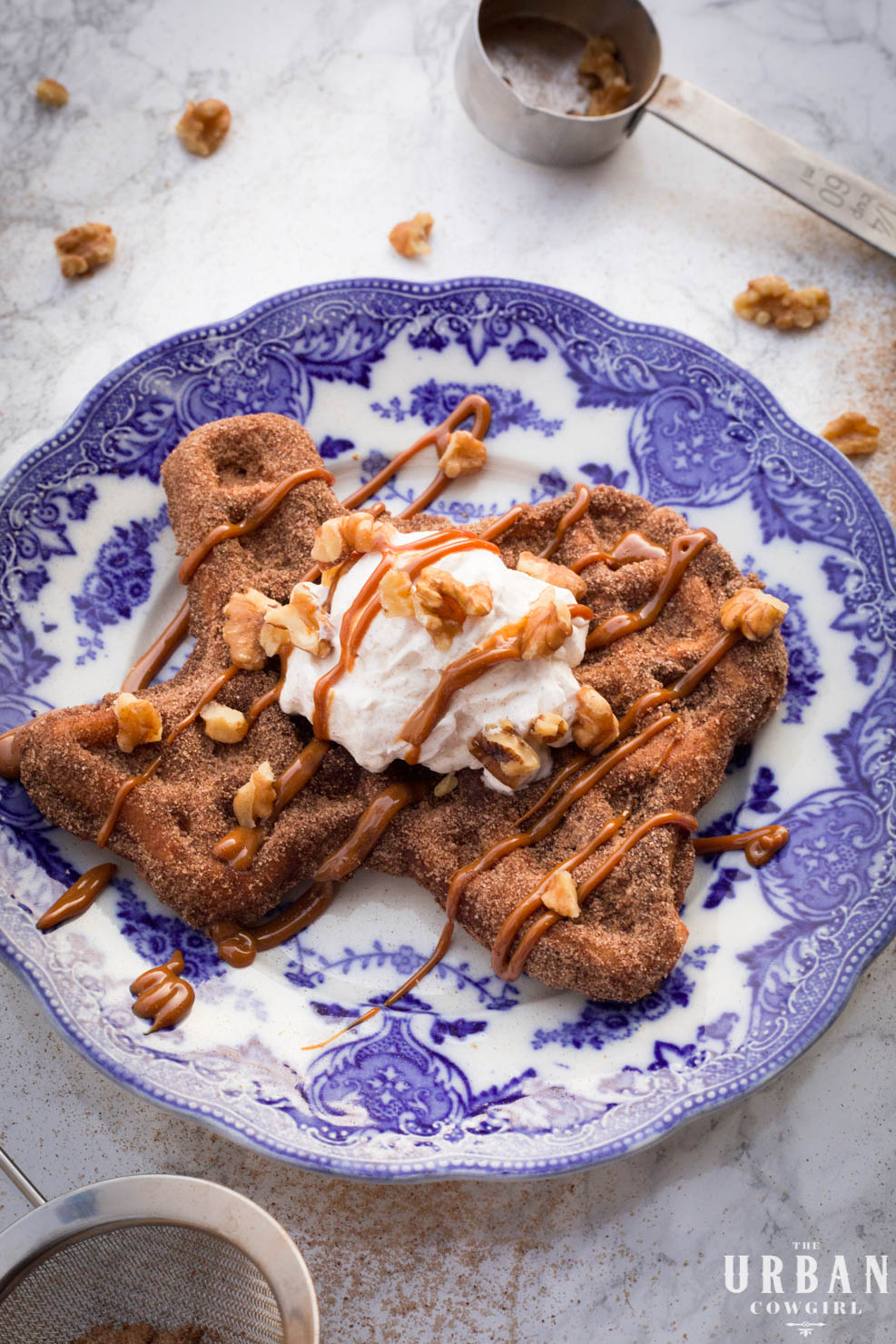 Churro Waffles - A completed waffle on a beautiful plated with whipped cream and dulce de leche