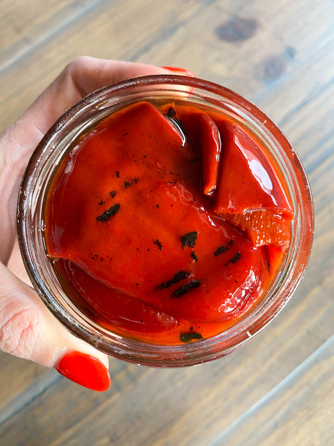 A jar of grilled piquillo peppers, opened, close up