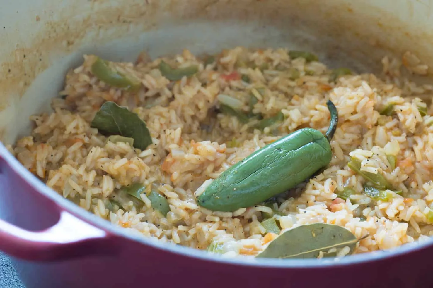 A roasted jalapeno atop mexican rice in a bowl.