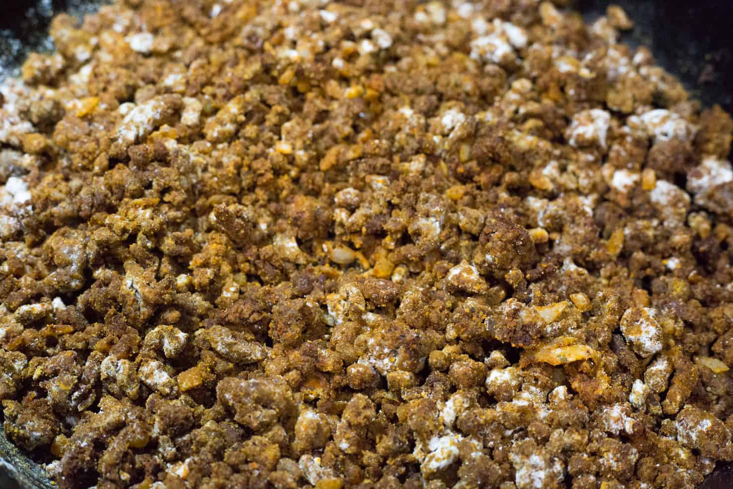 Ground beef and spices sauteed with flour in the pan.