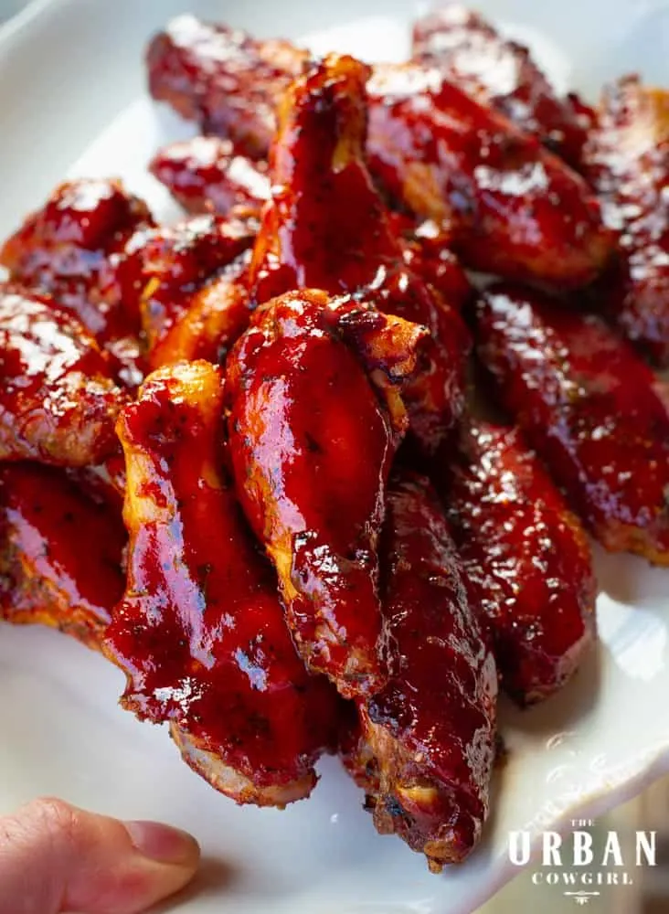 A generous heap of strawberry barbecue wings on a white plate.