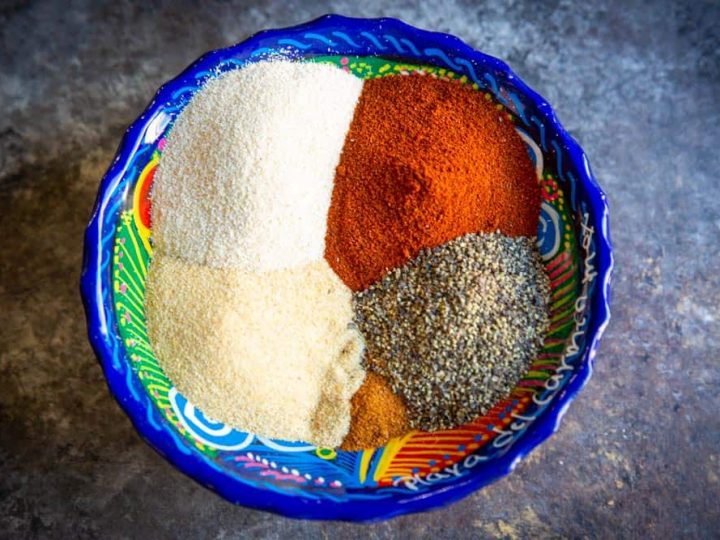 A colorful mexican bowl full of the spices to make our carne asada seasoning blend