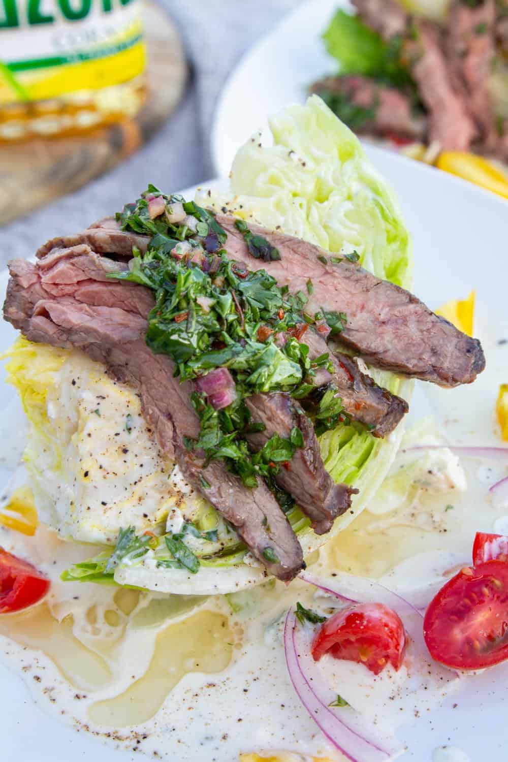 A wedge salad crowned with grilled skirt steak and green chimichurri sauce