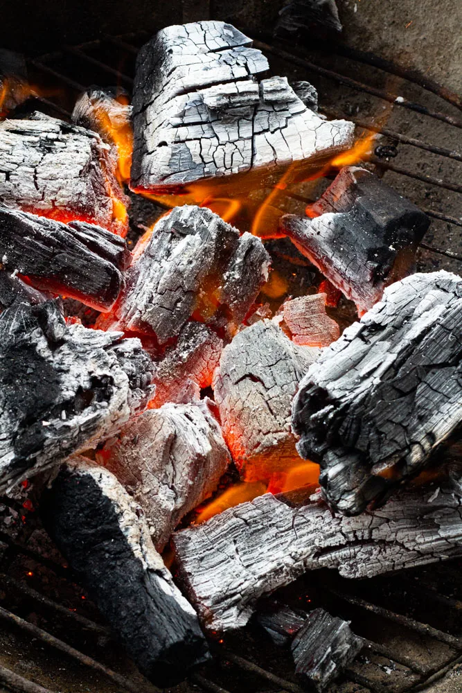 A close up of charcoal properly graying and almost ready to cook. 