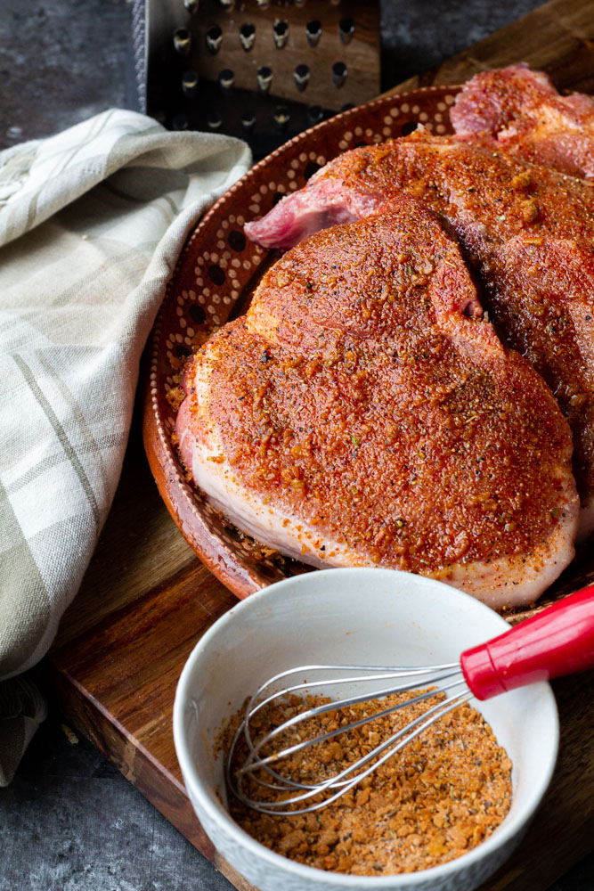 A mexican style plate full of raw pork chops, rubbed in our pork spice mixture.