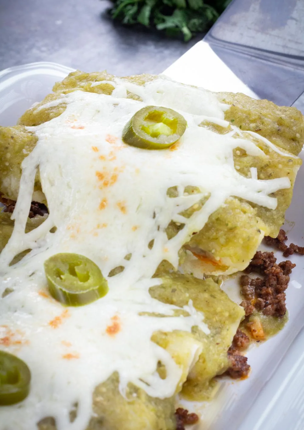 A dish of beef enchiladas with homemade green enchilada sauce