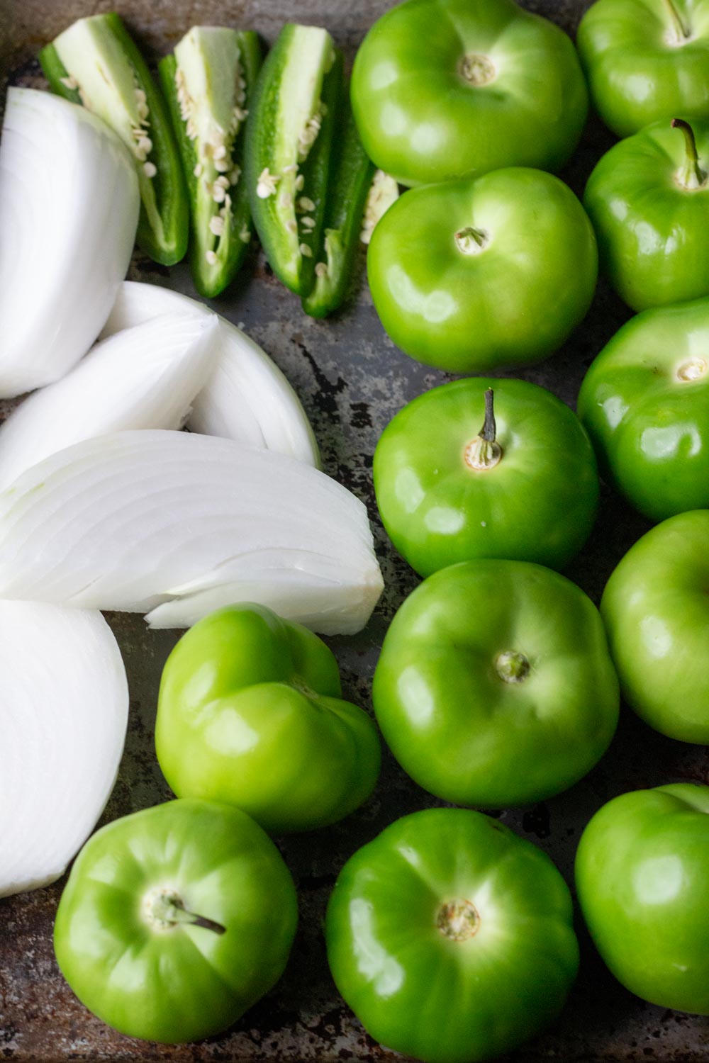 a baking sheet of tomatillos, onion, and chiles