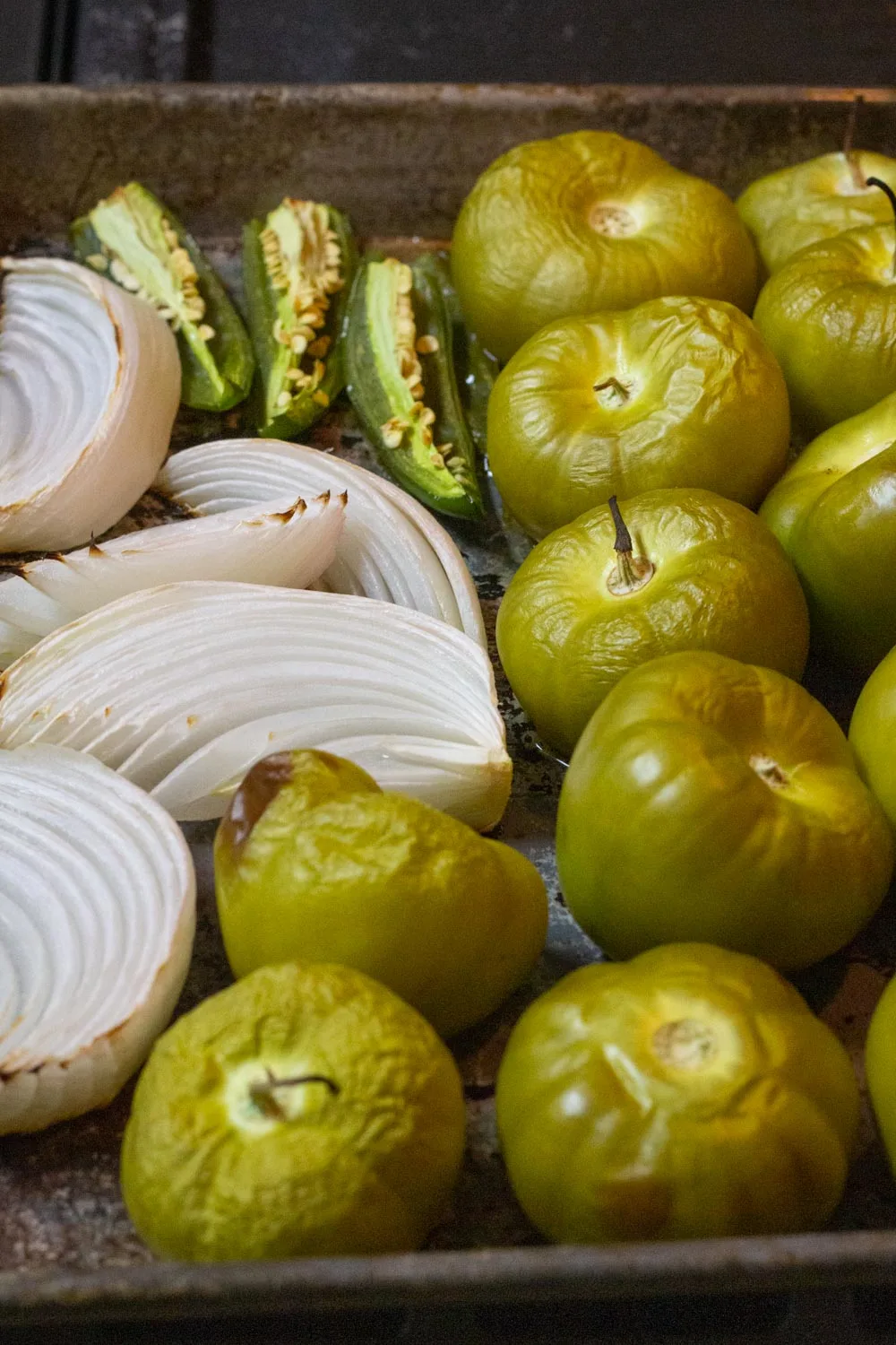 Roasted tomatillos which are wrinkly and a golden color. Onions and chiles are softened and golden.
