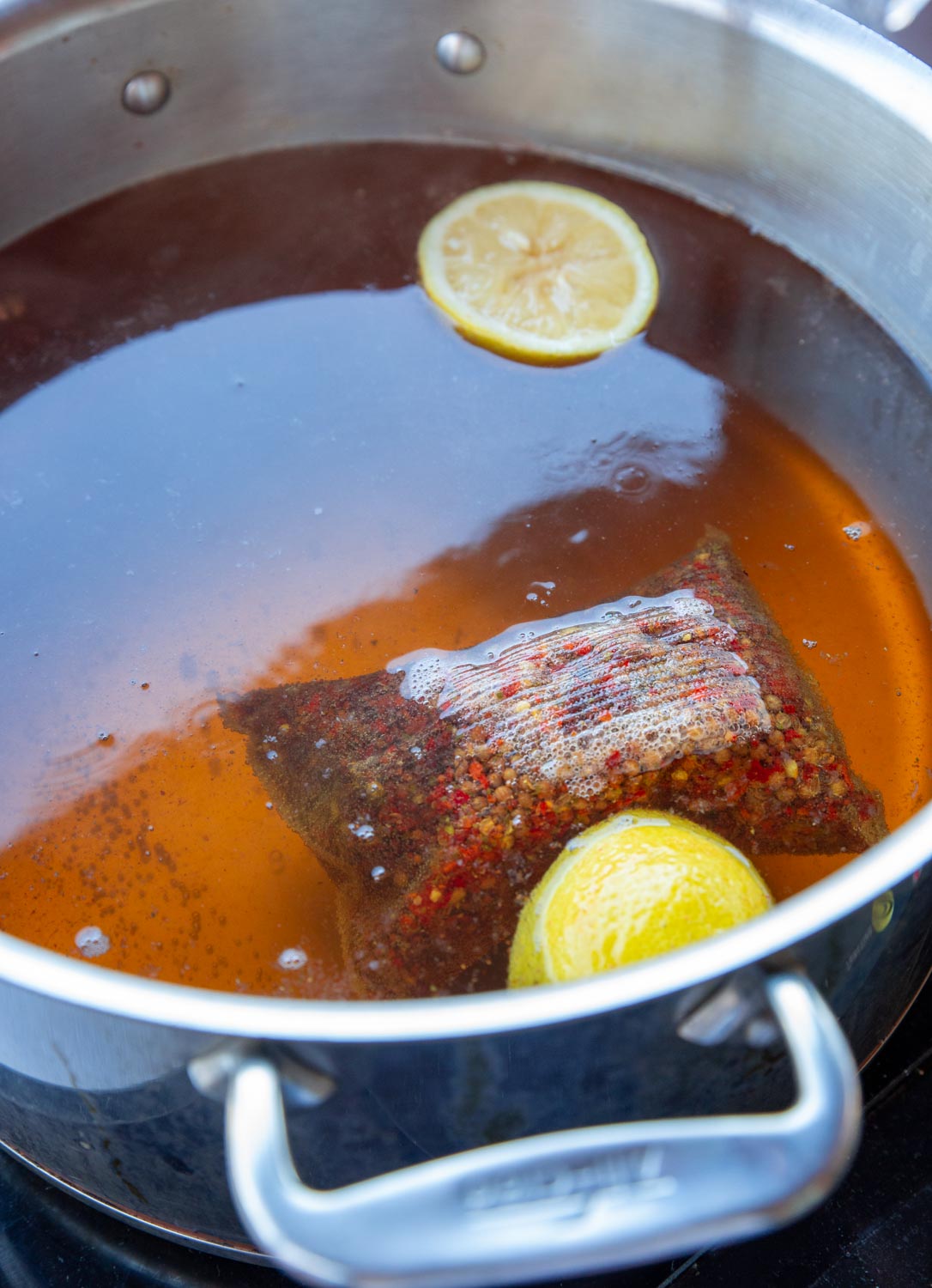 A bright red simmering broth for poaching shrimp