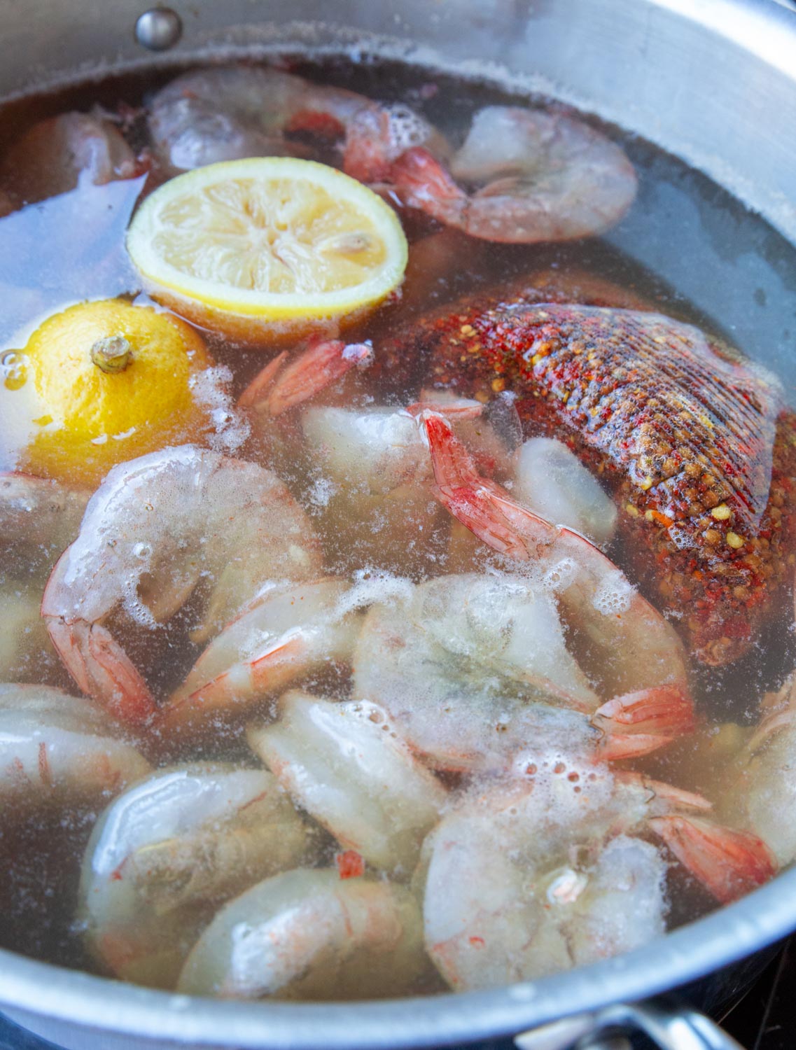 Raw shrimp recently placed into a bath of poaching liquid