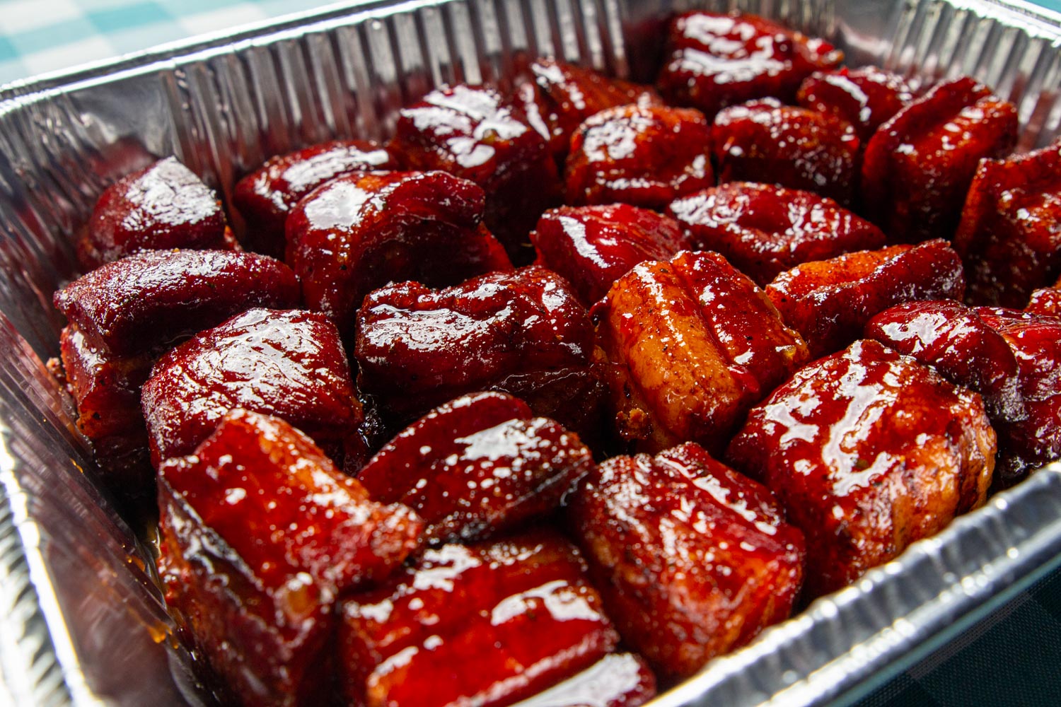 View of an aluminum pan of pork belly slices.