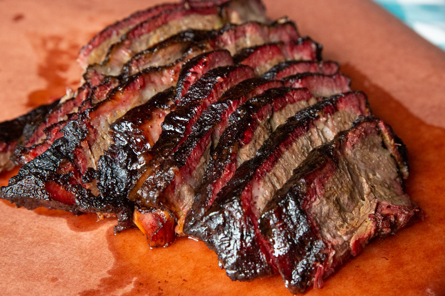 Beef Smoked Chuck Roast, sliced into brisket like slices, on peach butcher paper. 