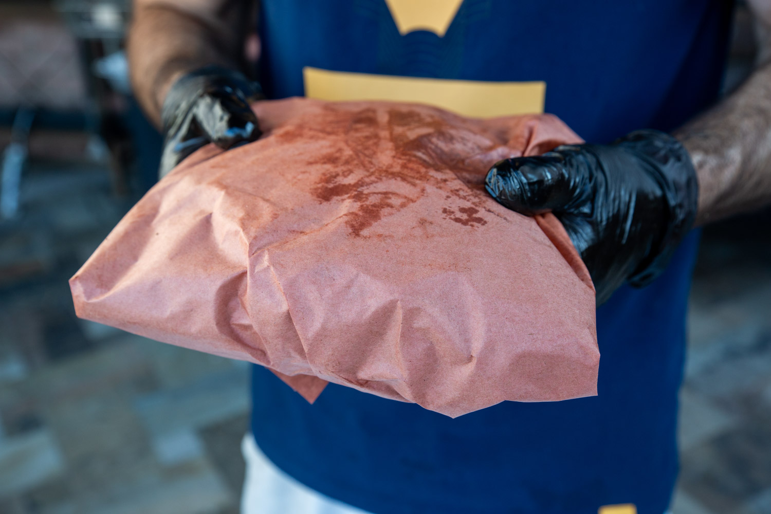 A chuck roast freshly wrapped tightly in peach butcher paper.