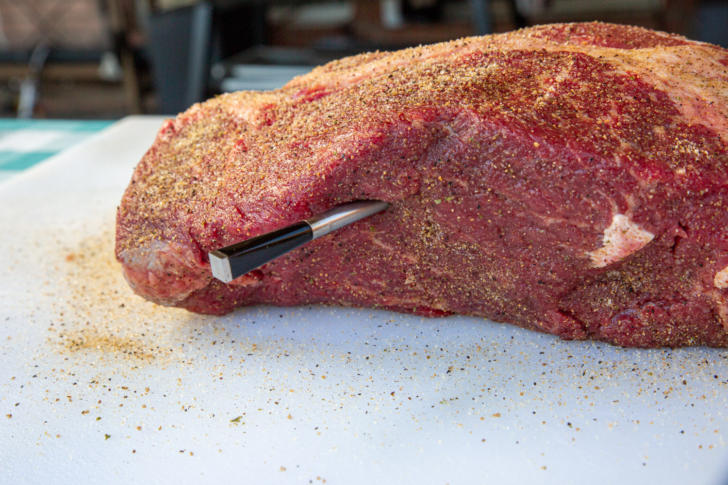 Raw chuck roast with thermometer probe inserted into the thickest part.