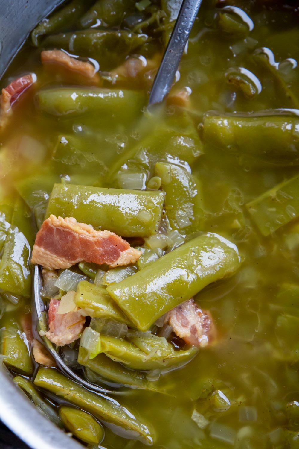 A large spoon containing roadhouse green beans