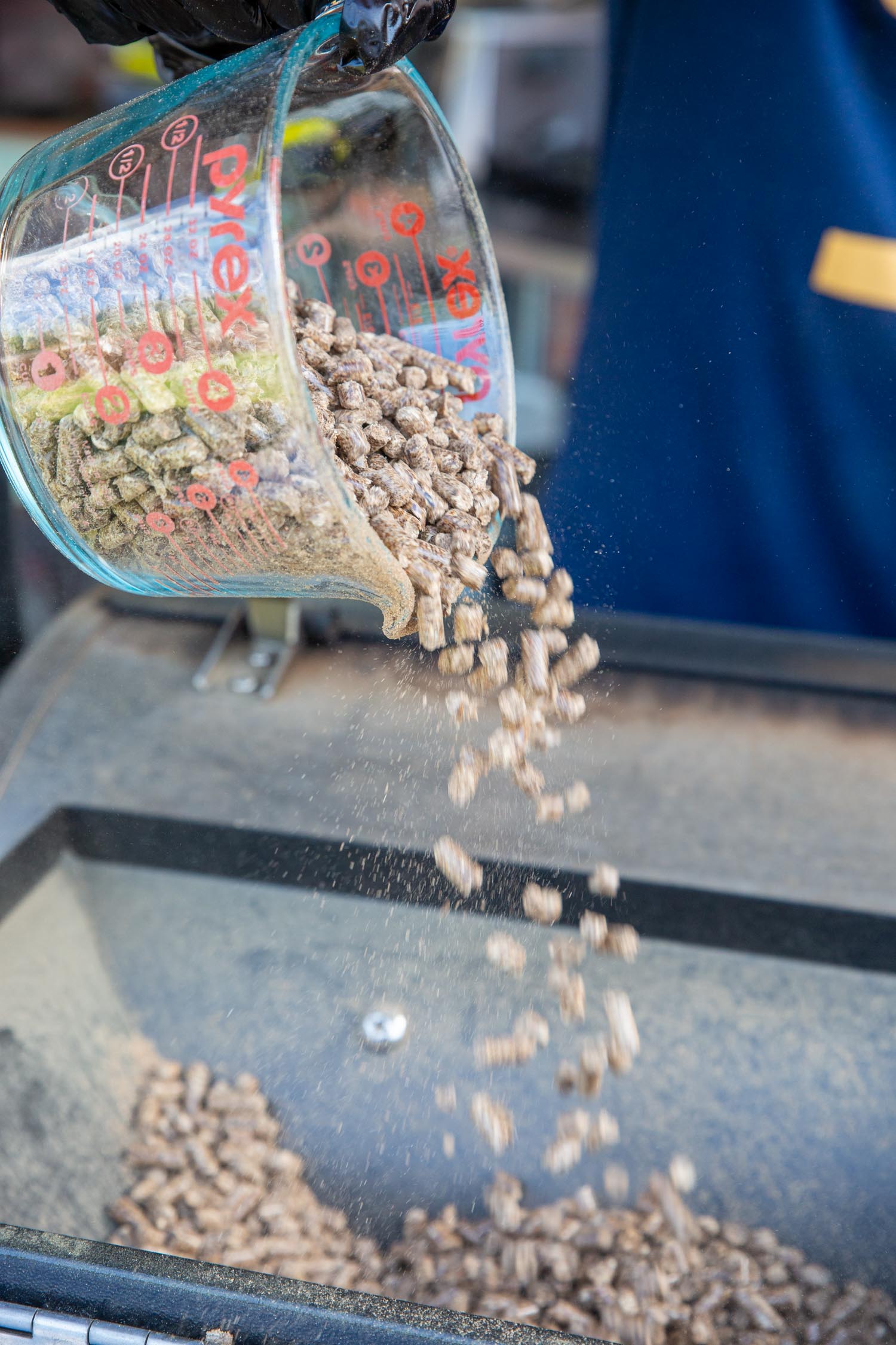 Pellets being pored into the hopped of the pellet grill.