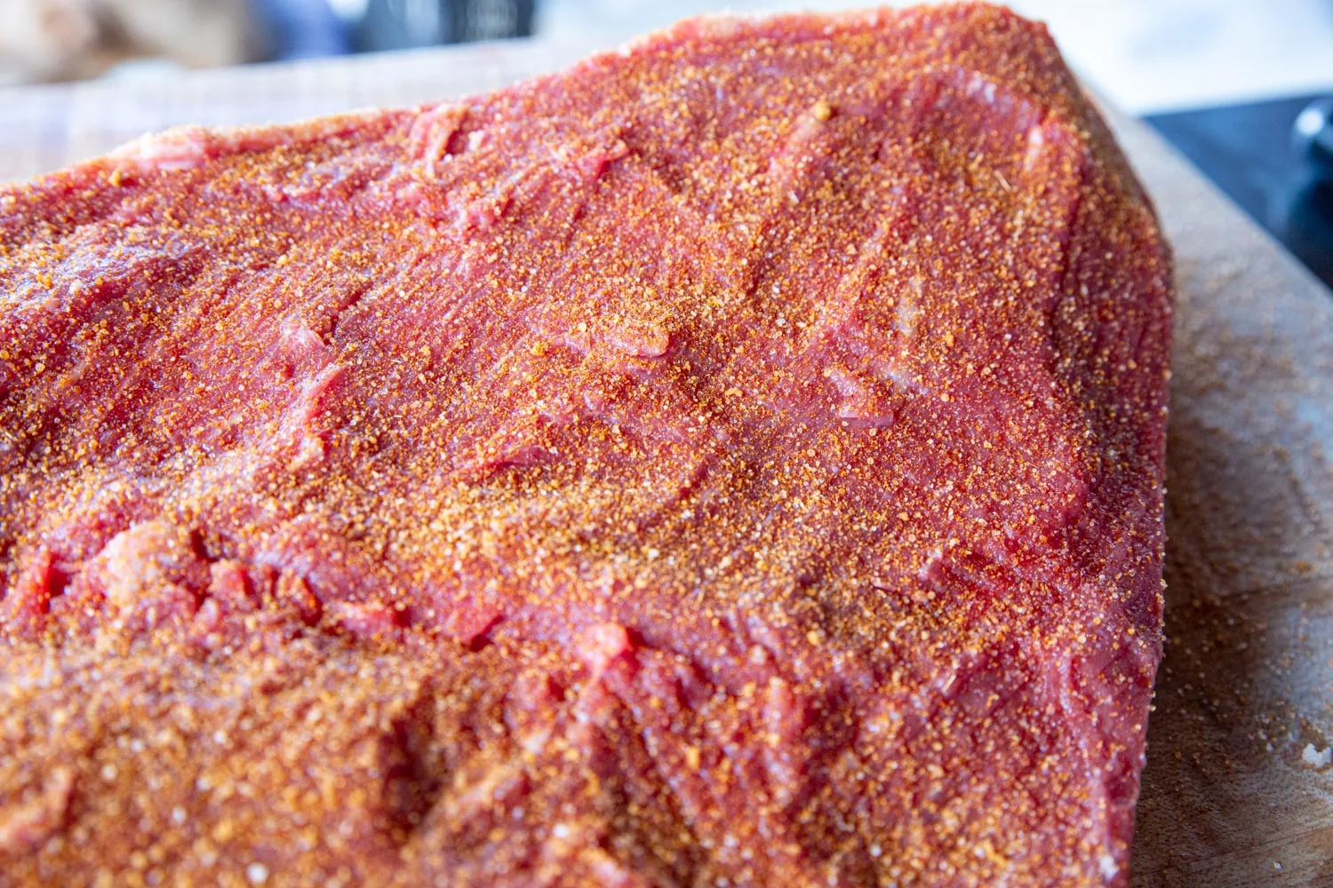 A close up of sprinkling the rub on the brisket where it can still breathe.