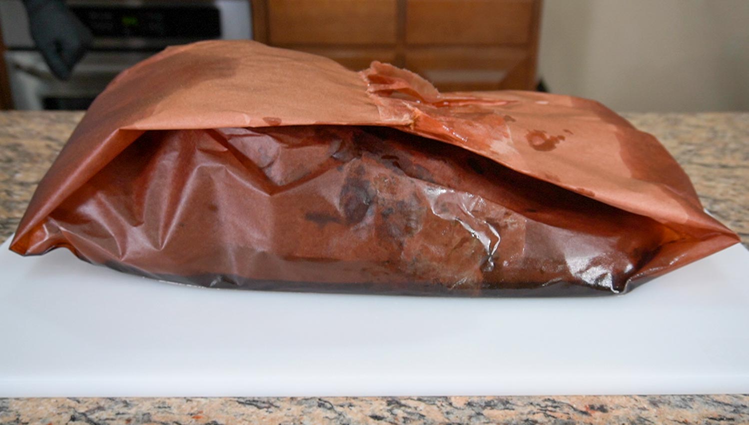 A brisket wrapped in peach butcher paper.