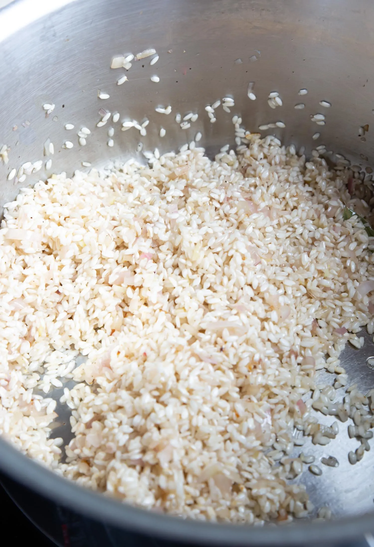 Arborio rice, shallot, and garlic toasting in a large stockpot.