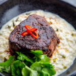 A big bowl of mole butter steaks sitting on top of green chile risotto