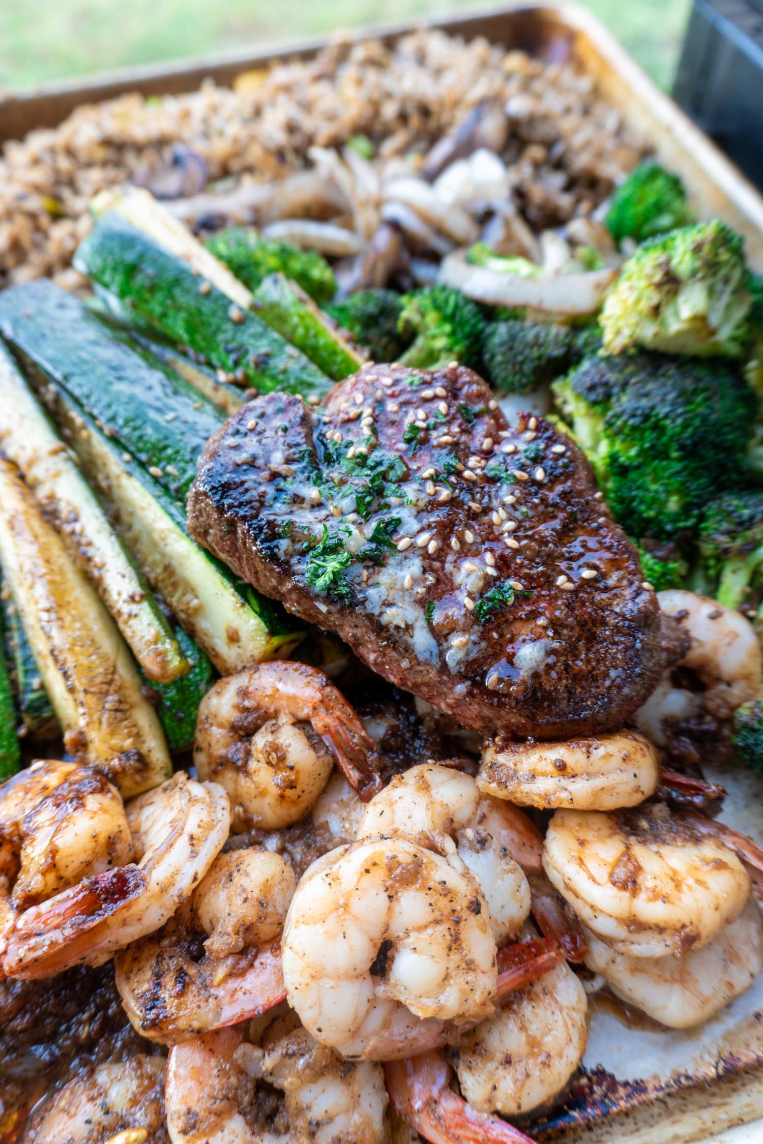 A cookie sheet loaded with hibachi favorites like fried rice, vegetables, and hibachi steak.
