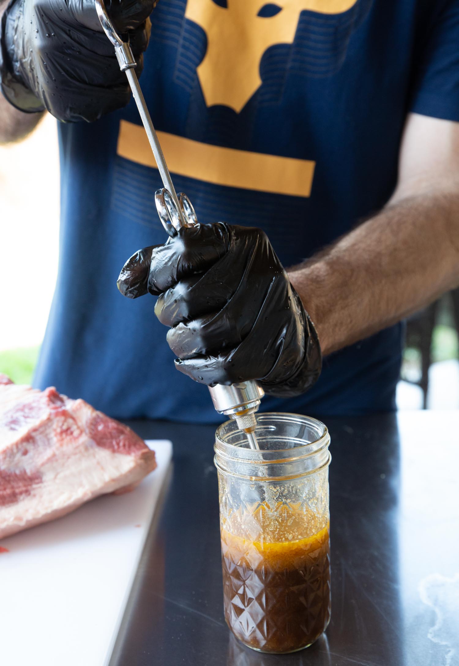A man pulling the meat injection liquid into a syringe.