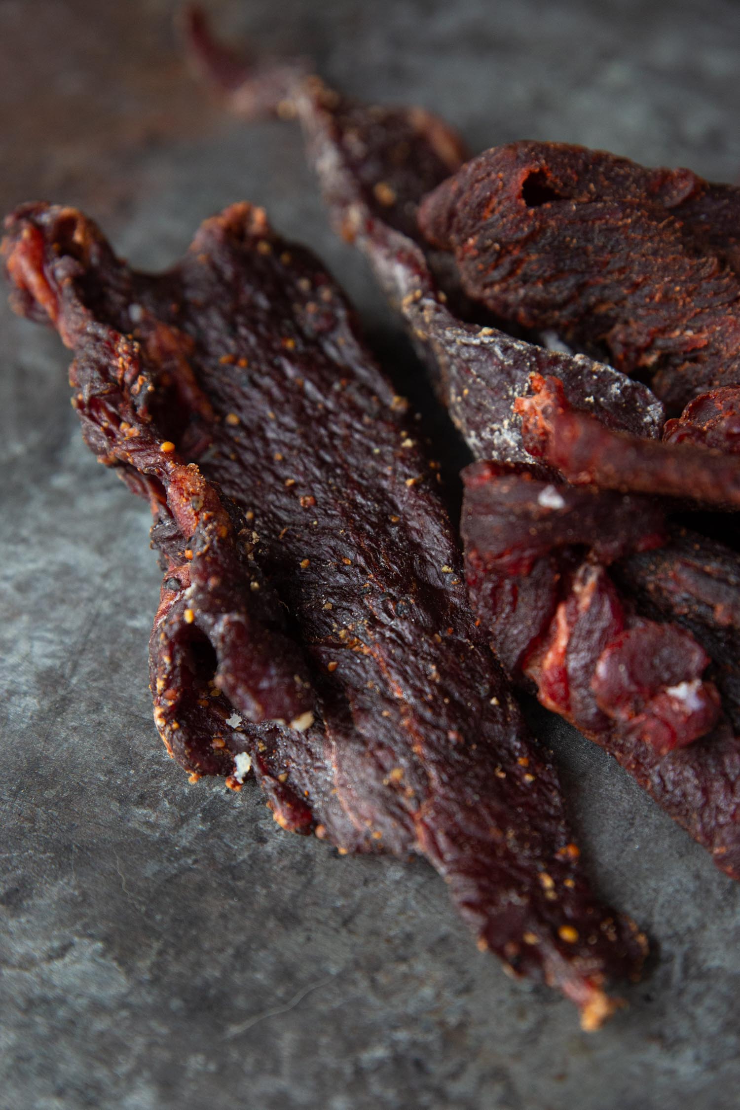Peppered beef jerky on a black background