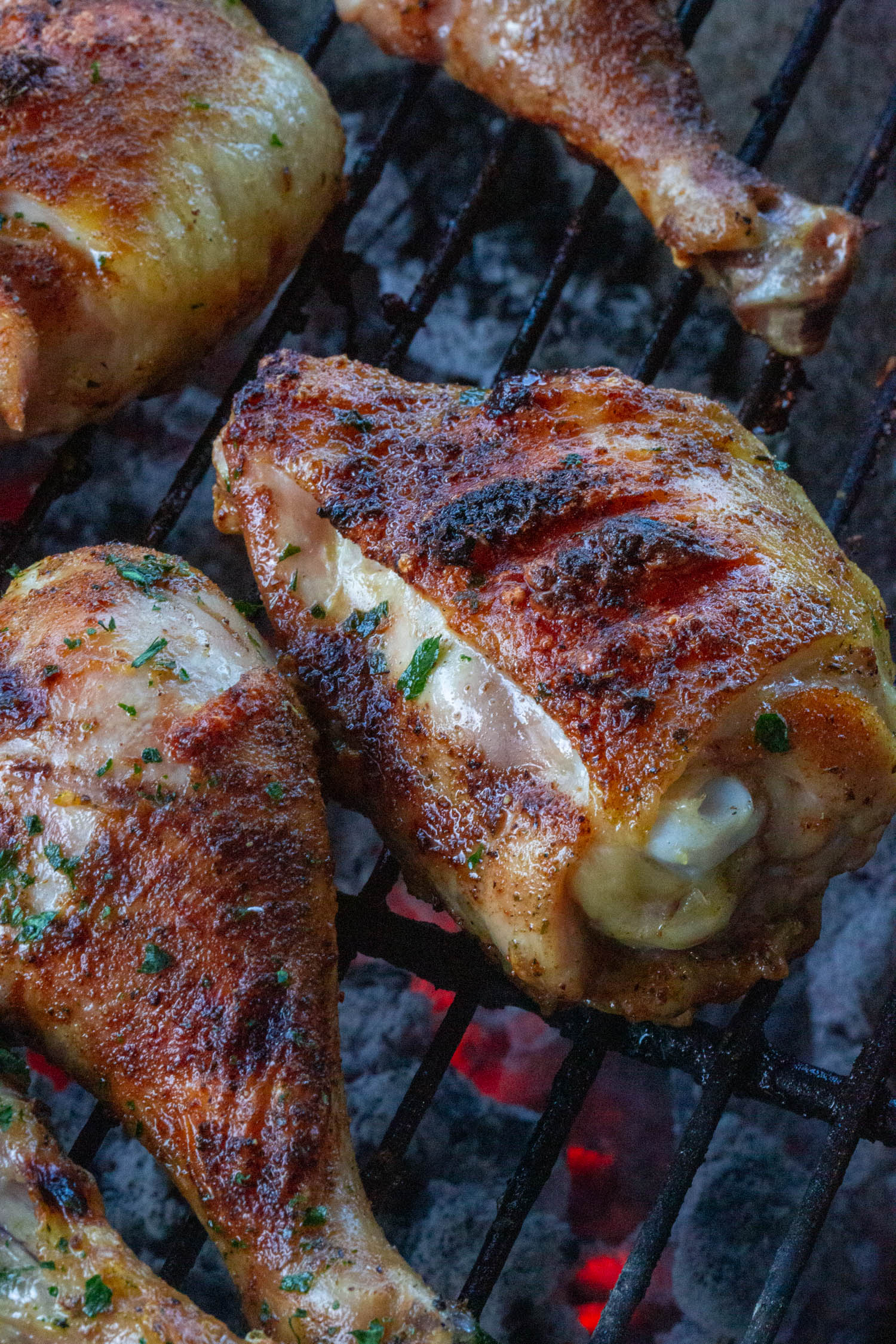 chicken thighs and legs arranged over a charcoal grill