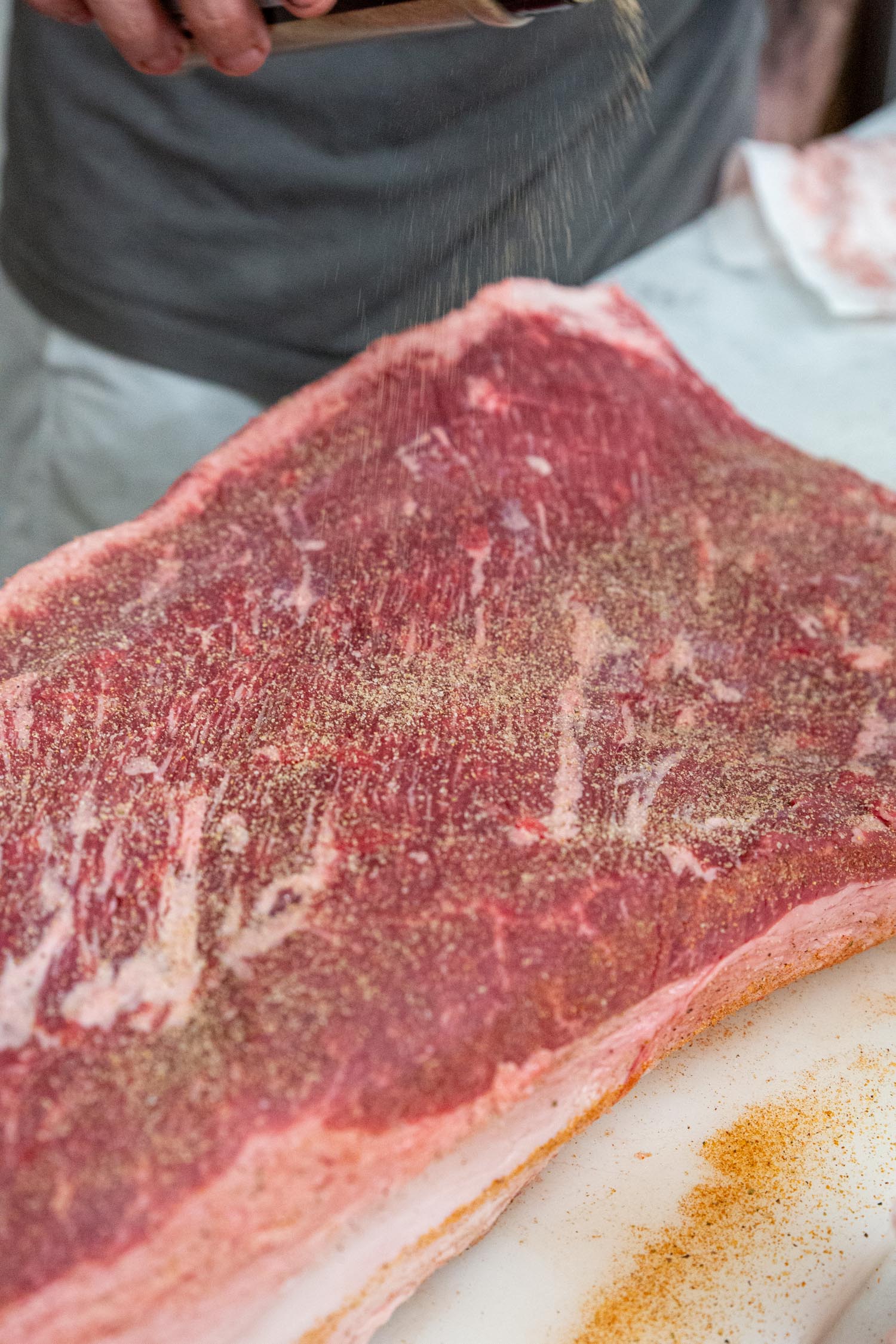 Seasoning the brisket with dry rub