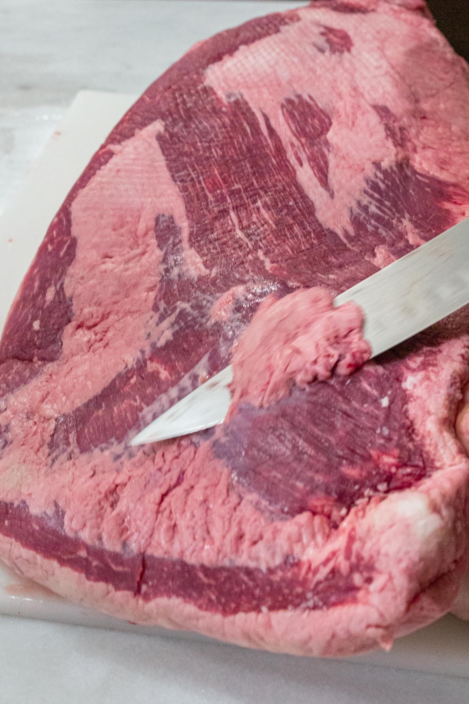 Trimming a brisket (the flat) with a sharp knife.