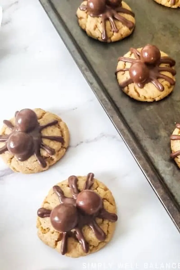 peanut butter cookies with chocolate spiders drawn on top