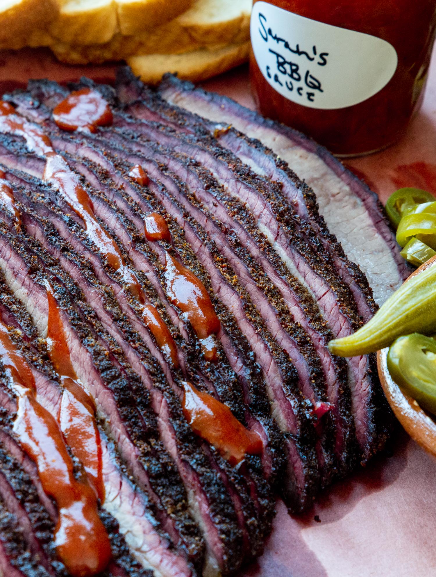 smoked brisket cooked at 250 degrees on a piece of butcher paper drizzled with barbecue sauce