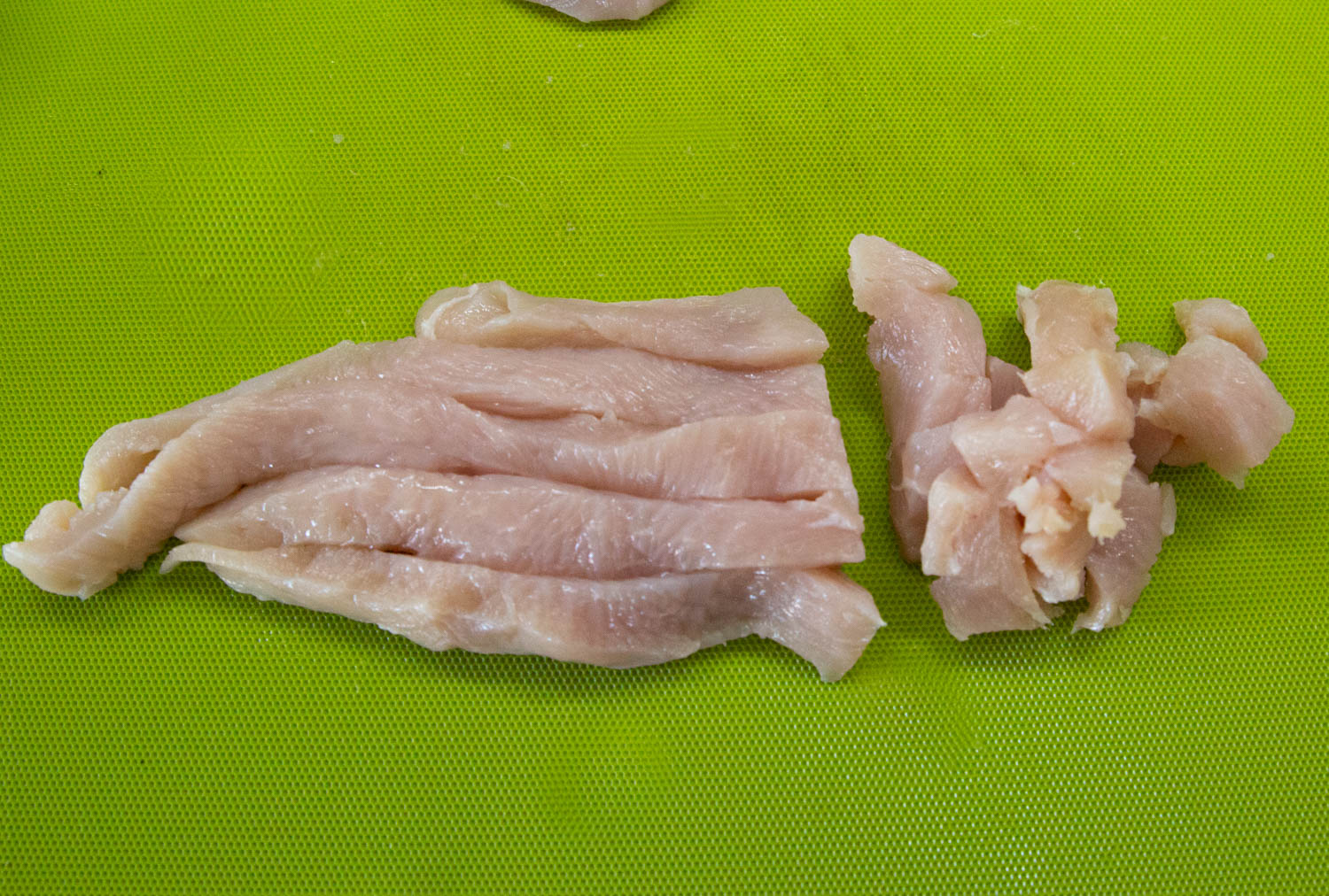 chicken breasts in ribbons being diced
