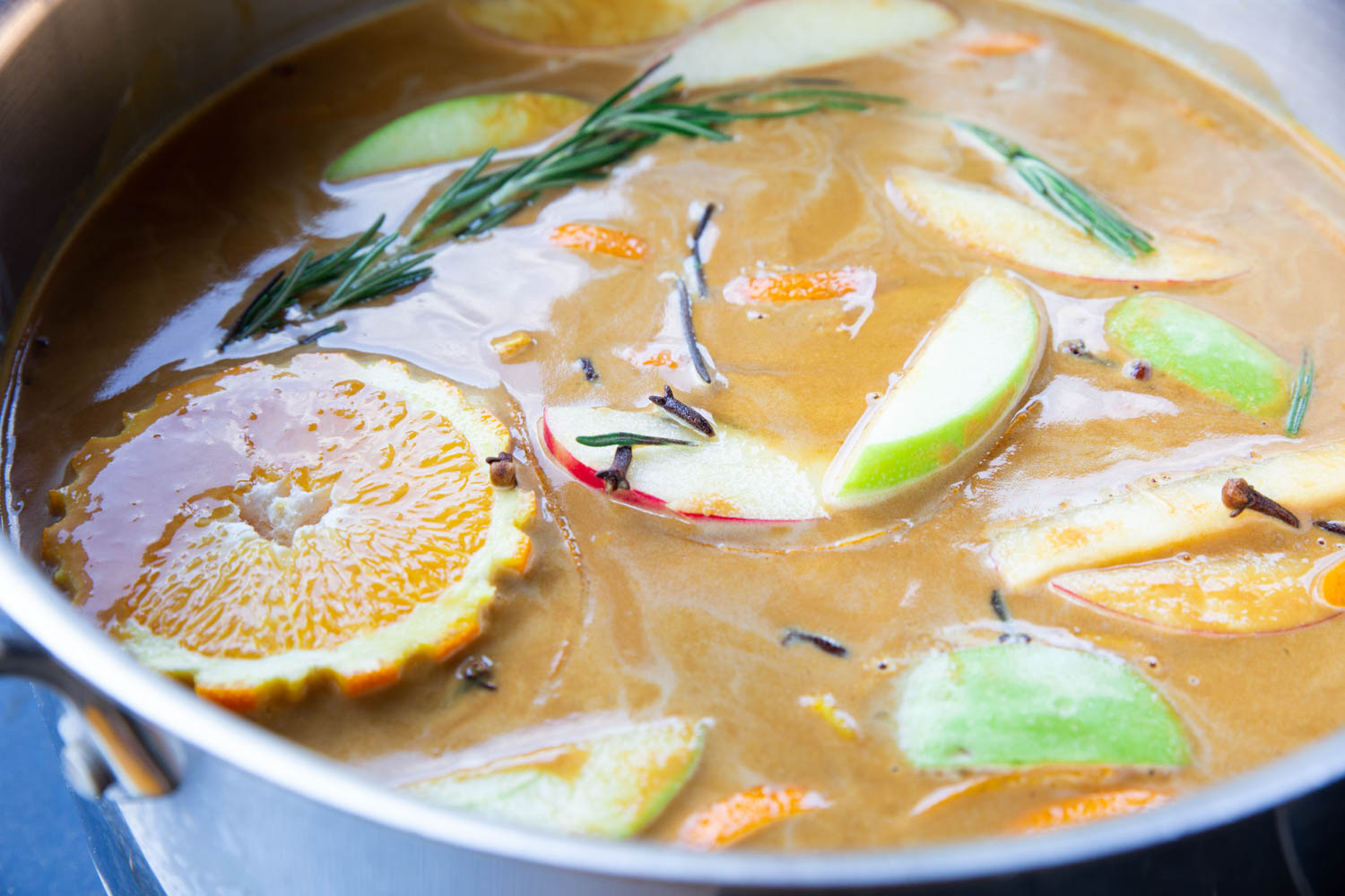 A simmering pot of apple cider and fruit