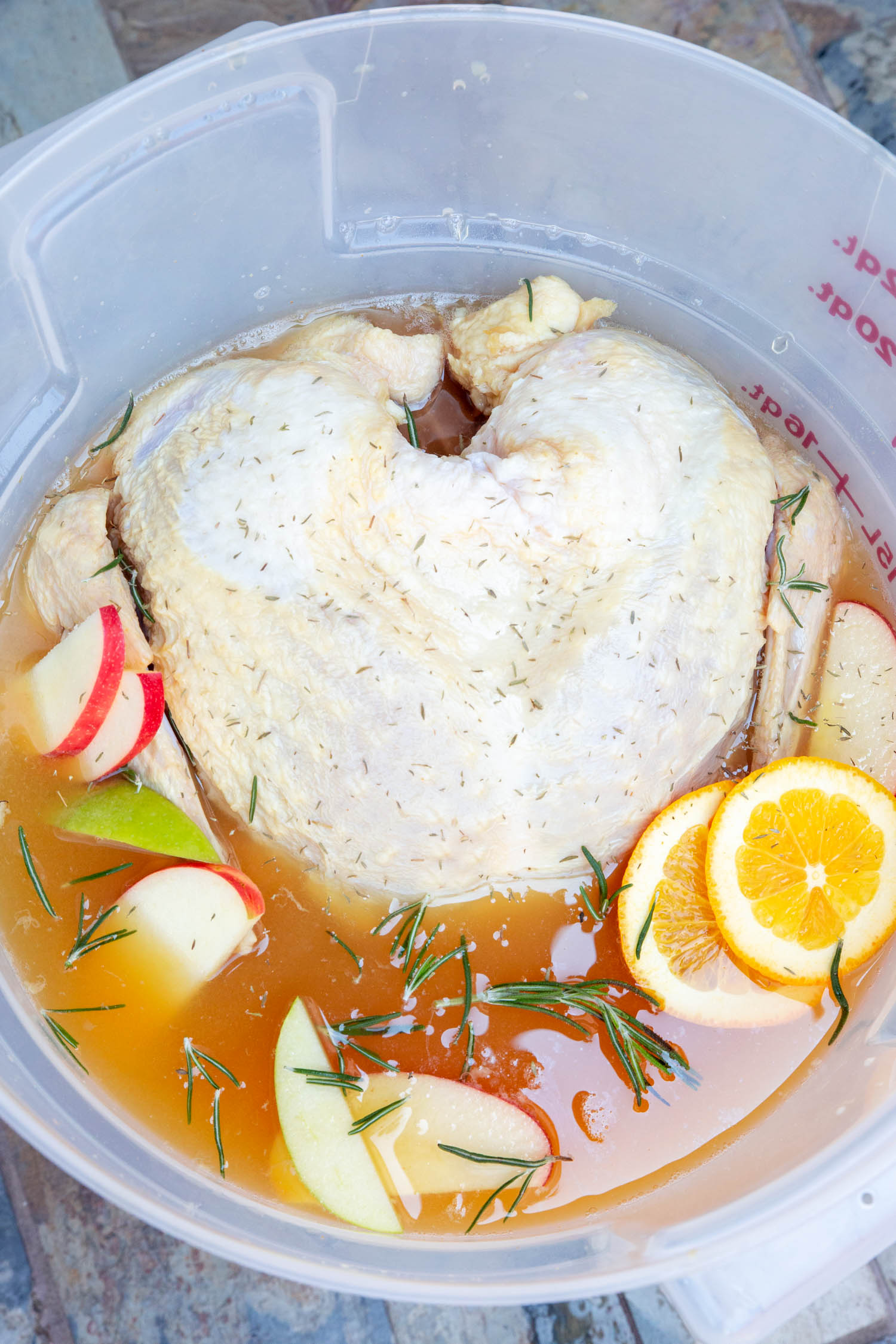 A raw whole turkey in a colorful brine