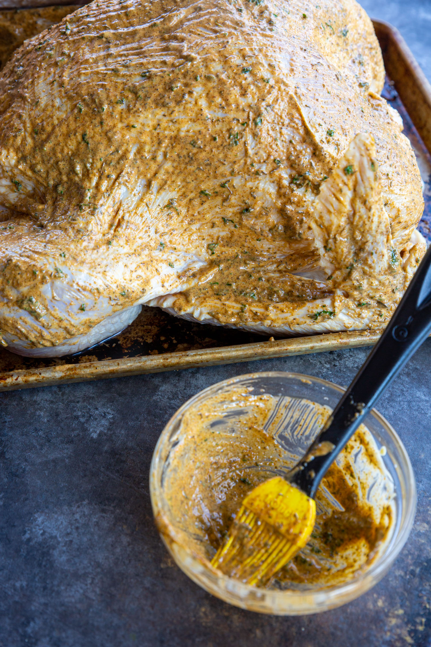 A turkey painted with all of the compound butter mixture, ready to be roasted.