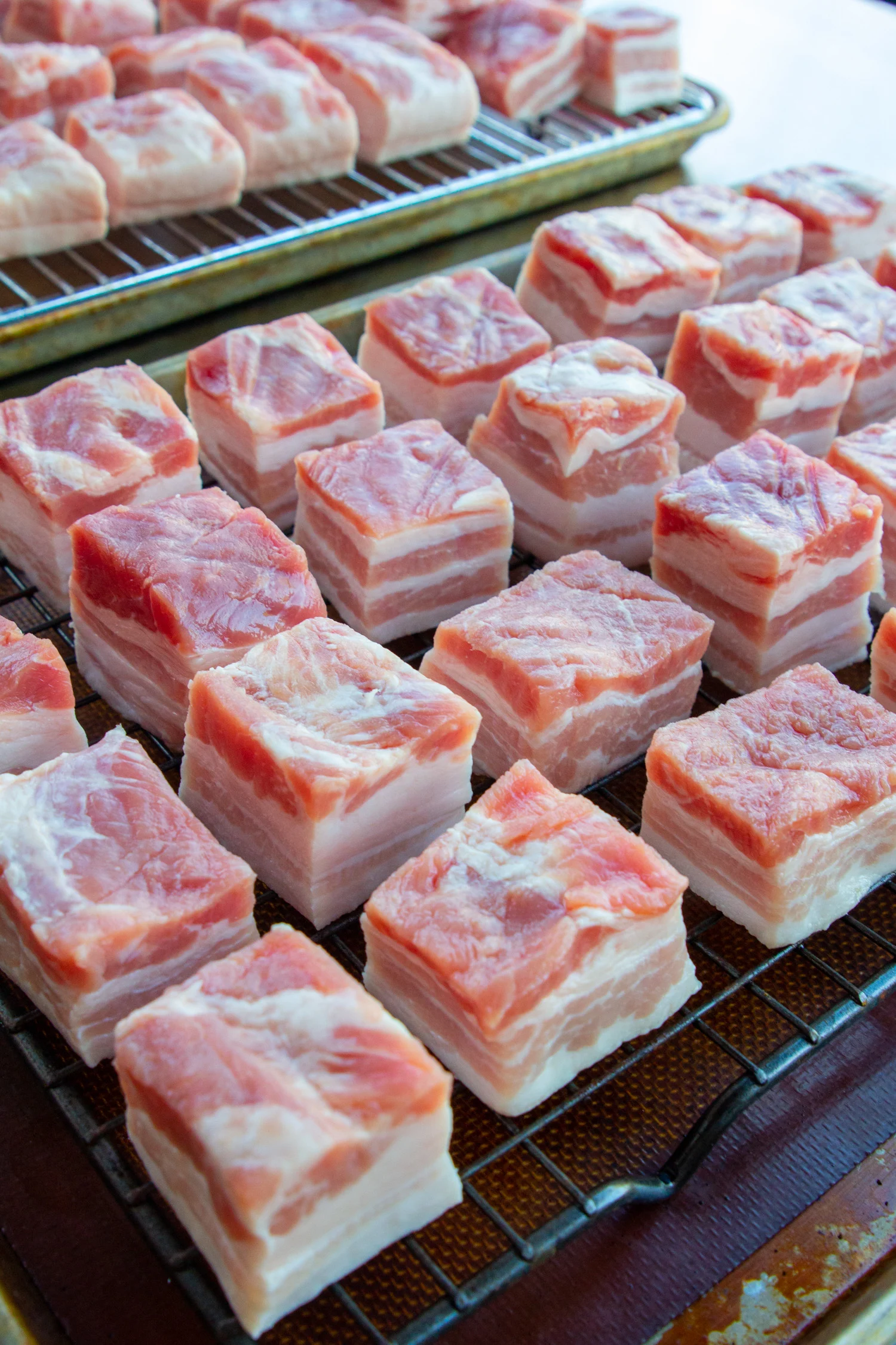 raw cubes of pork belly on a rack