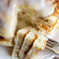A slice of a stack of cinnamon roll pancakes on a fork